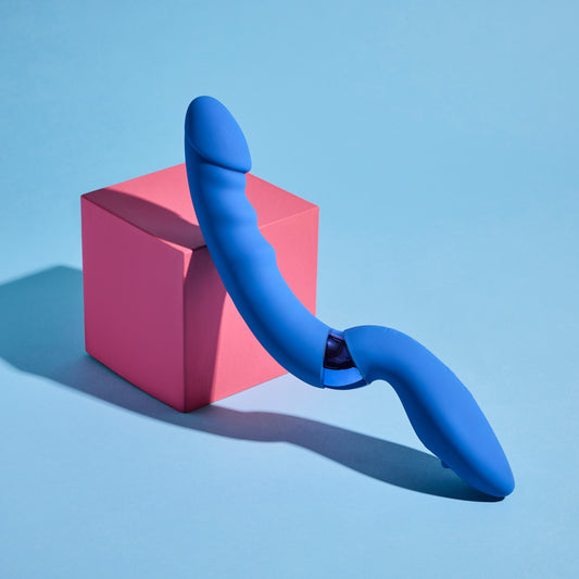 Blue curved vibrator on a pink cube against a blue background